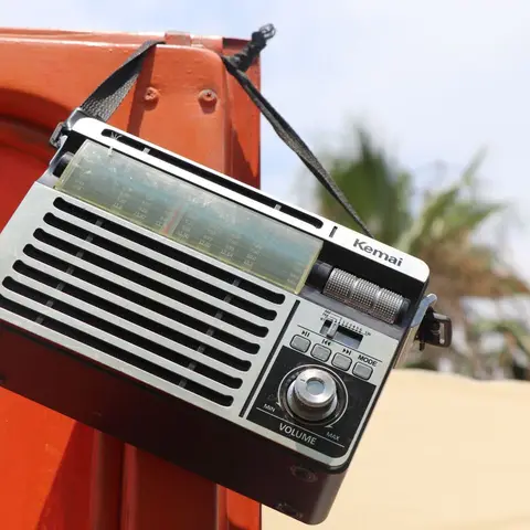 A retro-styled portable radio in warm wood and brushed metal
